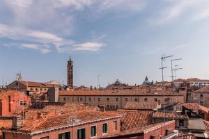 - une vue sur une ville avec des bâtiments et une tour de l'horloge dans l'établissement Charming loft with roof terrace close to S. Marco, à Venise