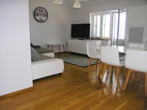 a living room with a white couch and a table at House Rozi in Rab