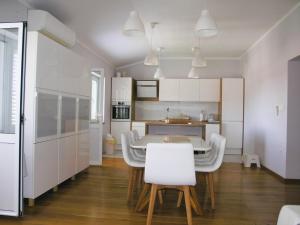 a kitchen and dining room with a table and chairs at House Rozi in Rab