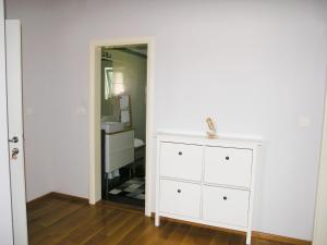 a bathroom with a white dresser and a mirror at House Rozi in Rab