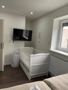 a baby room with a crib and a flat screen tv at Wohnen im Reihenhaus auf Zeit in Lübeck in Lübeck