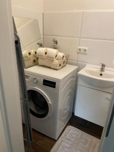 a washing machine in a bathroom with a sink at Wohnen im Reihenhaus auf Zeit in Lübeck in Lübeck