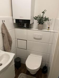 Baño blanco con aseo y lavamanos en Wohnen im Reihenhaus auf Zeit in Lübeck, en Lübeck