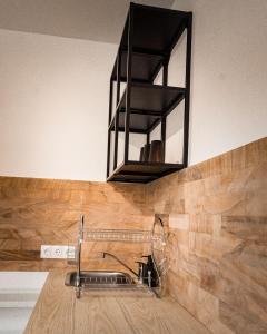una cocina con fregadero y un estante encima. en Maximus Apartments en Sighişoara