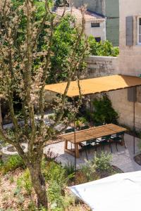 a picnic table and benches in a park with a tree at Maison Salix in Vallabrègues