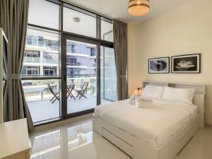 a bedroom with a bed and a large window at Key View - Loreto 3B, Damac Hills in Dubai Marina