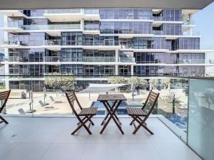 a table and chairs on a balcony with a building at Key View - Loreto 3B, Damac Hills in Dubai Marina
