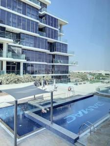 a swimming pool in front of a building at Key View - Loreto 3B, Damac Hills in Dubai Marina