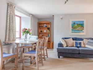 Honeysuckle Cottage في كينغسبريدج: غرفة معيشة مع طاولة وأريكة