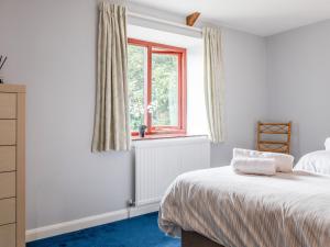 Honeysuckle Cottage في كينغسبريدج: غرفة نوم بسرير ونافذة