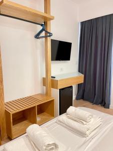 a room with a bed and a desk with a television at Hotel Aulona in Sarandë