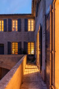 an empty corridor in a building with sunlight streaming through the windows at Maison Salix in Vallabrègues