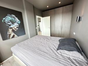 a bedroom with a bed with a painting on the wall at Cosy apartment centrally located in Reykjavik in Reykjavík