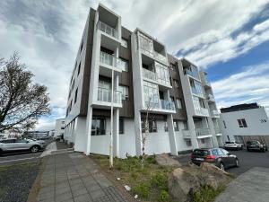 an apartment building with cars parked in a parking lot at Cosy apartment centrally located in Reykjavik in Reykjavík