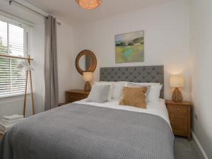 a bedroom with a large bed and a mirror at Rose Cottage in Ambleside