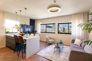 a kitchen and living room with a couch and a table at De Sheinkin in Tel Aviv
