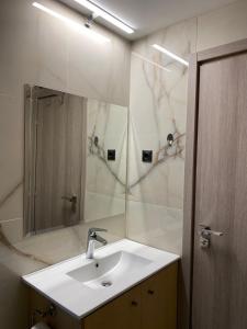 a bathroom with a sink and a mirror at blue view sea apartment in Ratzaklíon