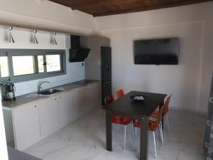 uma cozinha com uma mesa preta e cadeiras em blue view sea apartment em Ratzaklíon
