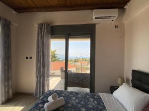 a bedroom with a bed and a window with a view at blue view sea apartment in Ratzaklíon