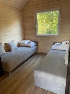 um quarto com duas camas num chalé de madeira em ŻURAWISKO - domki letniskowe Jarosławiec em Jarosławiec