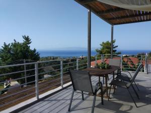 uma mesa e cadeiras num deque com vista para o oceano em blue view sea apartment em Ratzaklíon