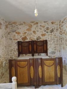 een kamer met houten kasten met een stenen muur bij Trullo Nicola in Ceglie Messapica