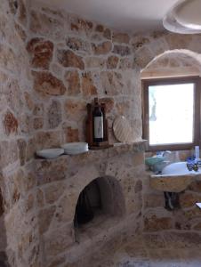 een stenen kamer met een stenen open haard en een raam bij Trullo Nicola in Ceglie Messapica