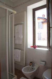 uma casa de banho com um lavatório, um WC e uma janela. em Hotel La Locanda em Stresa