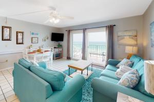 a living room with two blue couches and a table at Summit 723 in Panama City Beach
