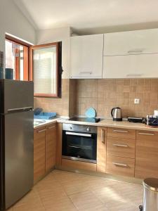 a kitchen with a stainless steel refrigerator and wooden cabinets at Apartment R in Risan