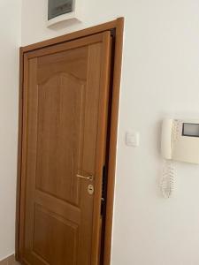 una puerta de madera con un teléfono en la pared en Apartment R, en Risan