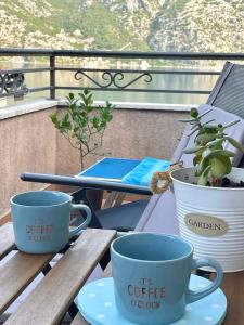 three coffee cups sitting on a table on a balcony at Apartment R in Risan