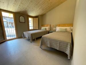 a bedroom with two beds and a window at CAL GALL rural Cerdanya in Bellver de Cerdanya 