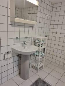 a white bathroom with a sink and a mirror at Gemütliche Oase - Geräumige Unterkunft in Sarreguemines