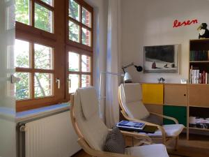 a room with two chairs and a table and windows at Art-Apartment-Leo in Bremerhaven