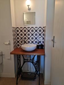 La salle de bains est pourvue d'un lavabo sur une table et d'un miroir. dans l'établissement L 'Aupinouse Chambre double Pivoine avec salle d'eau privative, à La Suze-sur-Sarthe