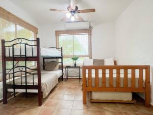 a bedroom with two bunk beds and a ceiling fan at Live an adventure in Taboga 1 in Taboga