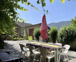 Tignac的住宿－La Treille，庭院配有桌椅和遮阳伞。