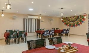 a dining room with tables and chairs and a large wall at Itsy By Treebo - Kashi Grand, BHU in Varanasi