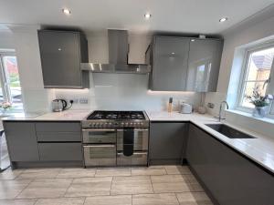 a kitchen with a stove and a sink at Thistle House - hot tub, parking in Kent