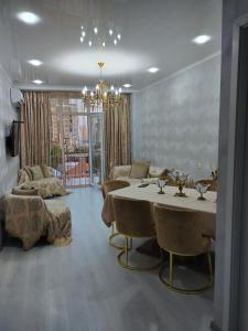 Family apartament في باتومي: غرفة معيشة كبيرة مع طاولة وكراسي