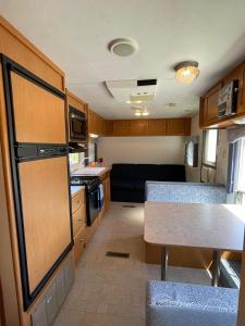 una piccola cucina con divano e tavolo in una roulotte di Quiet Country Rimrock Retreat a Hayden