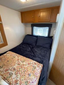 a small bedroom with a bed in a tiny house at Quiet Country Rimrock Retreat in Hayden