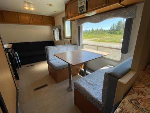 ein kleines Wohnzimmer mit einem Tisch und einem Sofa in der Unterkunft Quiet Country Rimrock Retreat in Hayden