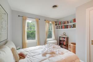 een slaapkamer met een wit bed en een boekenplank bij Silver Spring Rental 8 Mi to Washington, DC! in Silver Spring