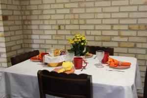 uma mesa com uma toalha de mesa branca e flores sobre ela em Casa MAgdeburg II - Central e completa em Pomerode