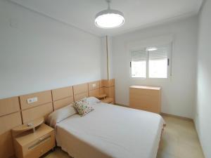 - une petite chambre avec un lit et une lampe dans l'établissement ACV - Torremar-2ª linea planta 2 Frontal 3h, à Oropesa del Mar