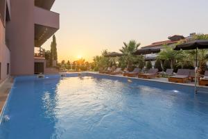 a large swimming pool next to a hotel at Hotel Yakinthos in Paralia Katerinis