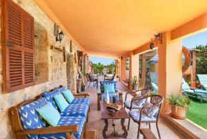 eine Terrasse mit blauen Sofas sowie einem Tisch und Stühlen in der Unterkunft YupiHome Finca Can Calistro in Inca