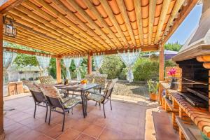 een patio met een tafel en stoelen onder een houten pergola bij YupiHome Finca Can Calistro in Inca